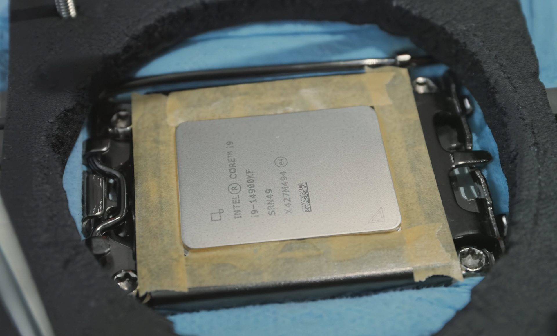 A close-up shot of a CPU on a motherboard, surrounded by a complex liquid nitrogen cooling setup.