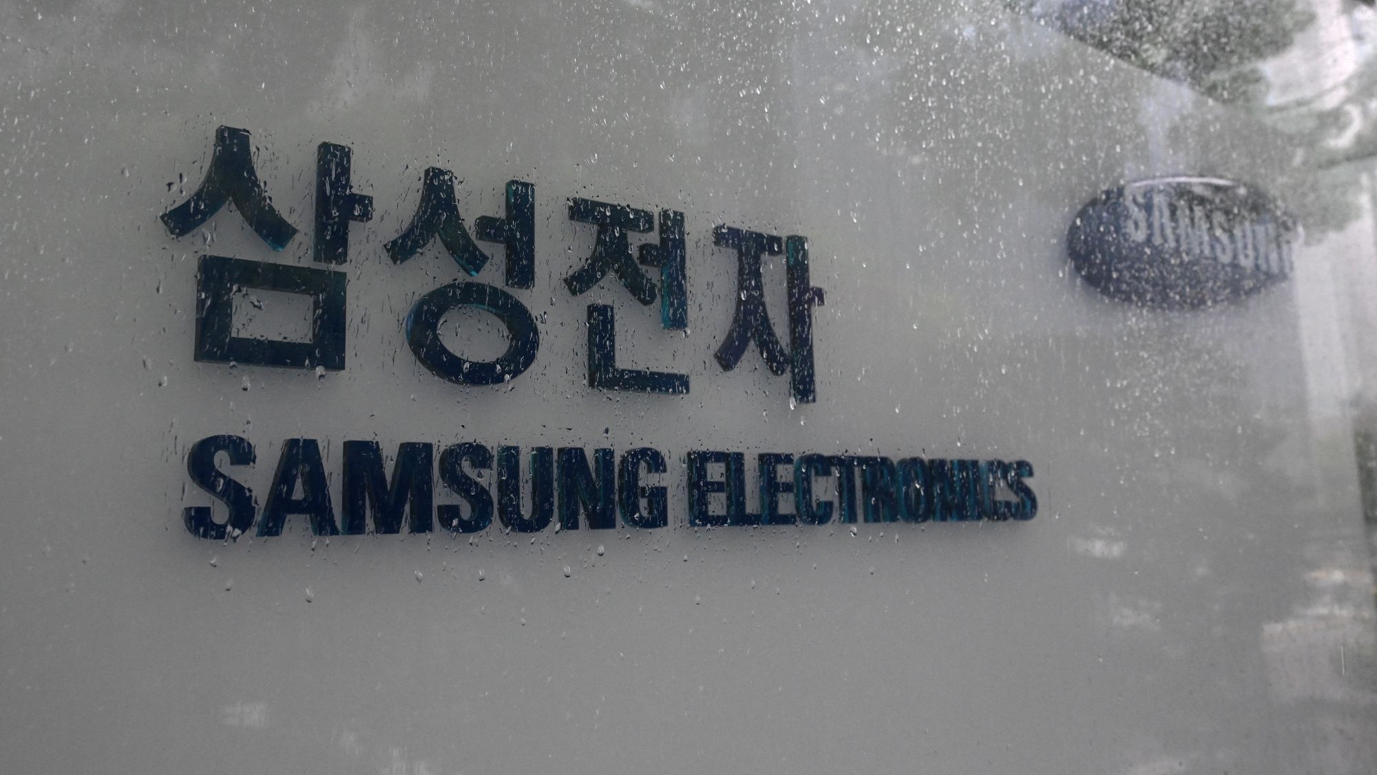 A graphic illustrating a stark contrast between two piles of money, one extremely large and one very small, representing the bonus disparity at Samsung.