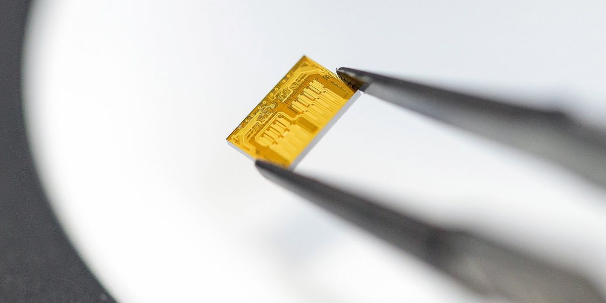 Close-up of photonic integrated circuit with laser arrays glowing under test